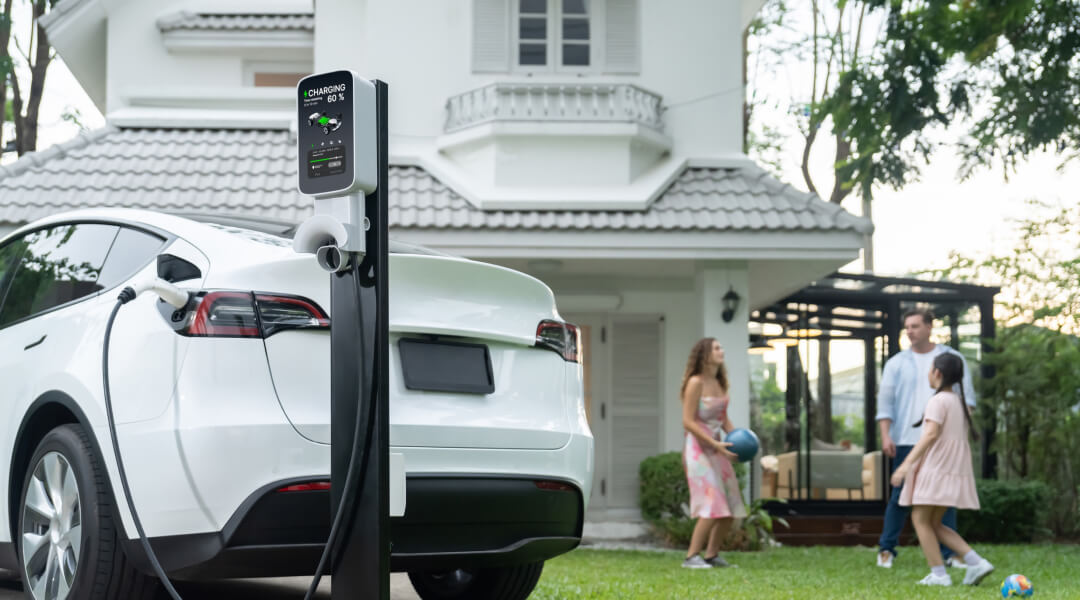 Une famille recharge leur Tesla Model X à domicile, illustrant l'importance d'installer une borne de recharge.