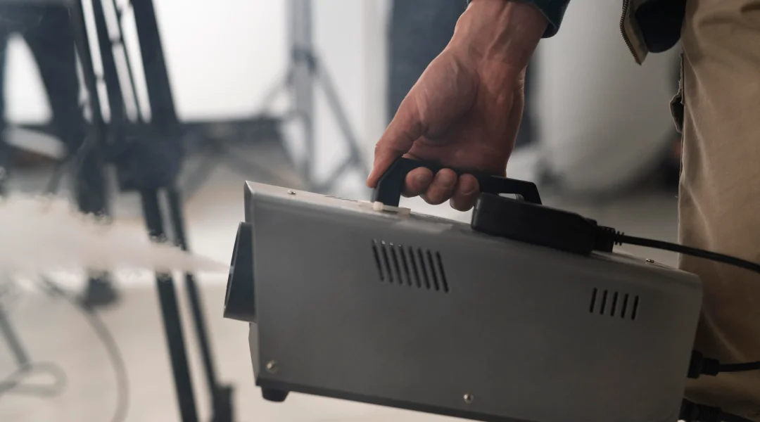 Une personne tient une génératrice automatique de fumée, prête à créer des effets visuels.